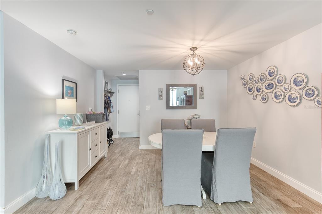 A dining room features a white sideboard, a round table with gray chairs, and wall-mounted plates — 241 RIVERSIDE DRIVE UNIT 405, HOLLY HILL, FL