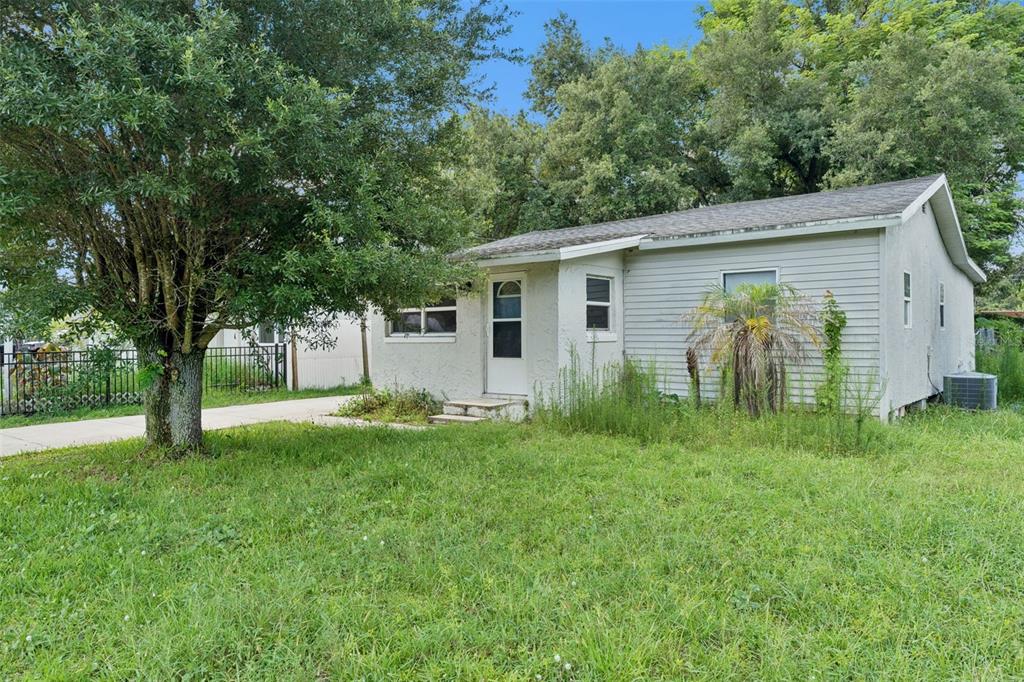 A single-story house with light-colored siding, a front door, and a large tree in front — 5000 HUPPEL AVENUE, ORLANDO, FL
