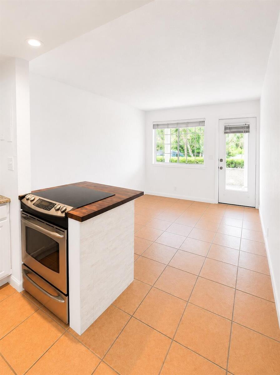 A kitchen area features a stainless steel stove, a wood countertop, and light-colored tile flooring — 3115 Park Avenue # 3, Singer Island FL 33404, SINGER ISLAND, FL