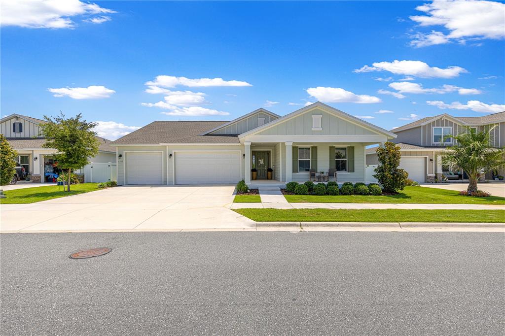 A light green single-story house with a three-car garage and a covered front porch — 6237 SW 71ST TERRACE ROAD, OCALA, FL