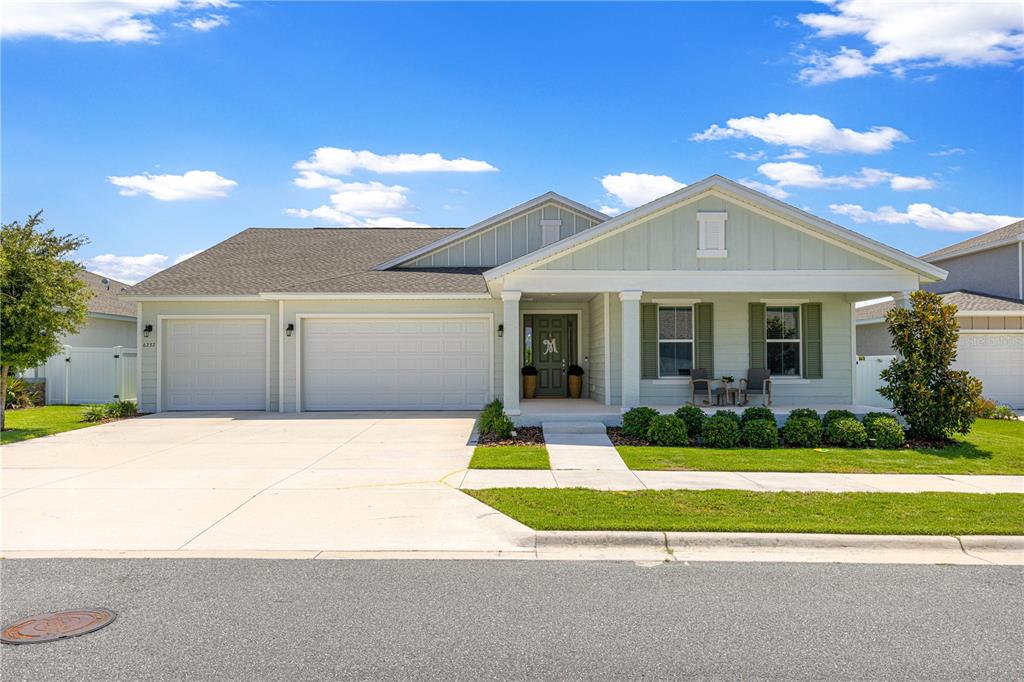 A single-story house with light green siding, a three-car garage, and a covered front porch — 6237 SW 71ST TERRACE ROAD, OCALA, FL