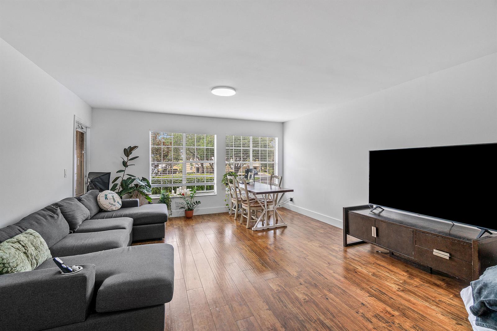 A living and dining room with hardwood floors, a gray sectional sofa, and a television — 6283 La Costa Drive, Boca Raton FL 33433, BOCA RATON, FL