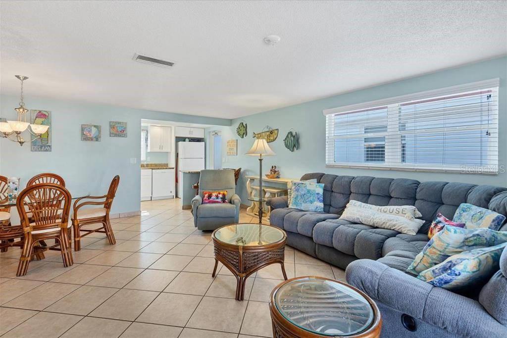 A living and dining area features tile flooring, a blue sofa, and a rattan table — 6154 MIDNIGHT PASS ROAD UNIT D13, SARASOTA, FL