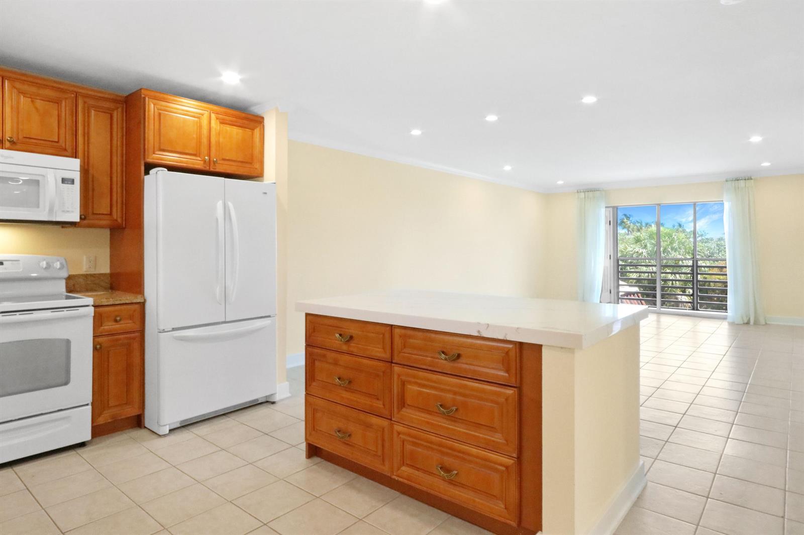 A kitchen with wood cabinets, white appliances, and a central island with a stone countertop — 717 S Us Hwy 1 # 712, Jupiter FL 33477, JUPITER, FL