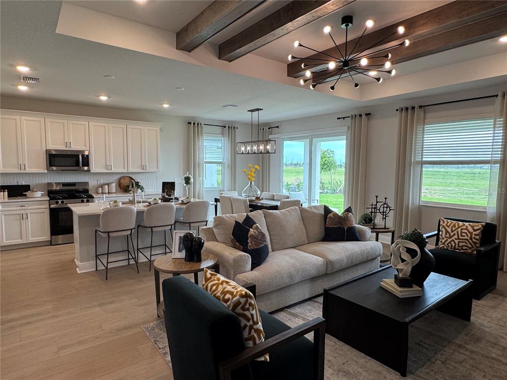 A kitchen island with a stainless steel sink faces a room with tile flooring — 8725 CANARD COVE, PALMETTO, FL