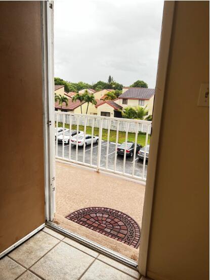 A view from an interior doorway looking out onto a balcony with a parking lot — 6289 Lear Drive # 302, Atlantis FL 33462, ATLANTIS, FL