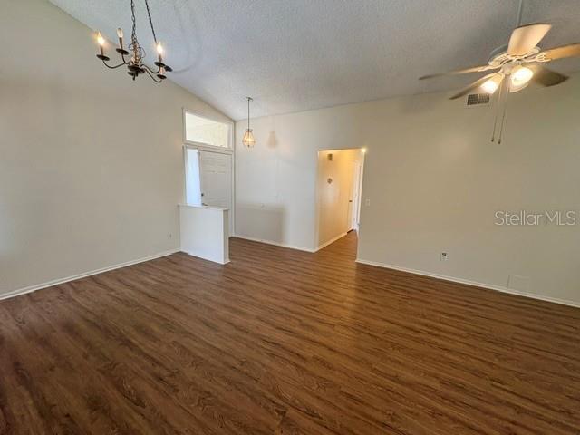 A spacious living room features vaulted ceilings, wood-look flooring, a ceiling fan, and two chandeliers — 2224 FAIRMONT CIRCLE, ORLANDO, FL