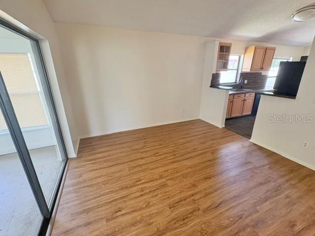 An open dining area features wood-look flooring, white walls, and a view into the kitchen — 2224 FAIRMONT CIRCLE, ORLANDO, FL