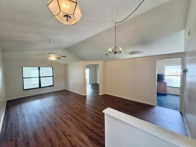 An open-concept living area features vaulted ceilings, dark wood-look flooring, and multiple light fixtures — 2224 FAIRMONT CIRCLE, ORLANDO, FL