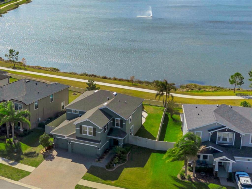 A two-story gray house with a brick driveway, attached garage, and landscaped front yard — 19613 LONG LAKE RANCH BOULEVARD, LUTZ, FL