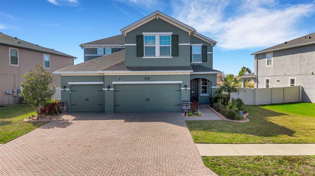 A backyard features a swimming pool with a spa, stone waterfall, and patio overlooking a lake — 19613 LONG LAKE RANCH BOULEVARD, LUTZ, FL