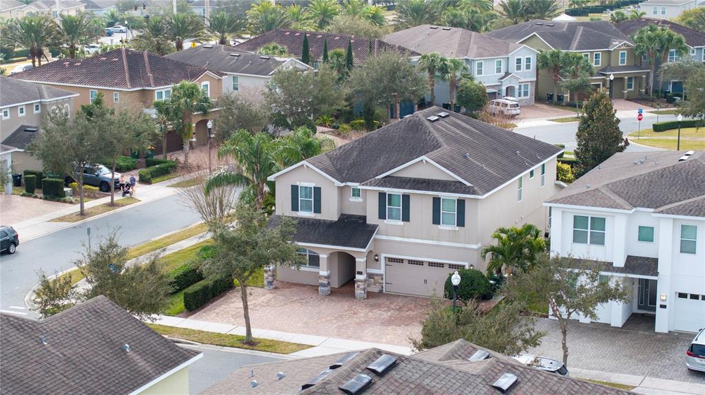 An aerial view shows a two-story suburban house with a paved driveway and shingled roof — 7600 MACKINAW LANE, KISSIMMEE, FL