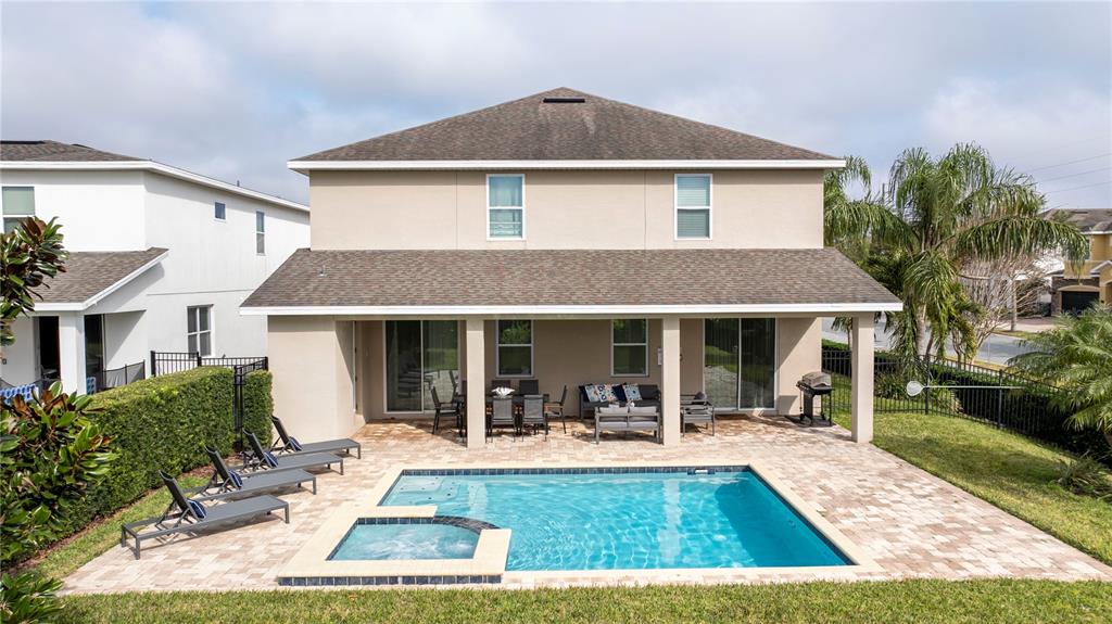 A two-story house features a covered patio, a swimming pool, and a spa — 7600 MACKINAW LANE, KISSIMMEE, FL