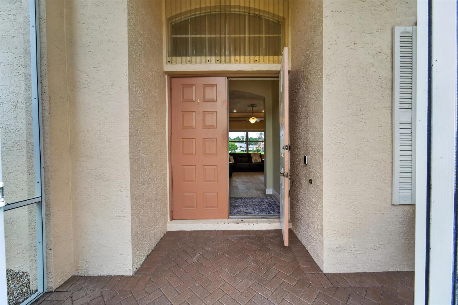 A front entrance with a herringbone brick porch and an open door revealing an interior — 512 SW Lake Manatee Way, FL 34986, FL