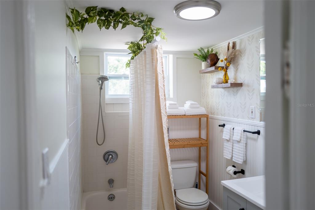 A bathroom features a shower-tub combination, a toilet with shelving, and a vanity — 127 17TH AVENUE S, ST PETERSBURG, FL