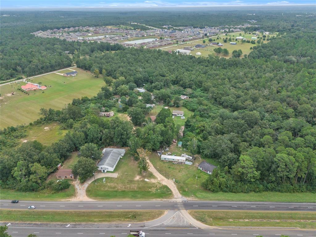 An aerial view shows a rural property with several buildings and a road in the foreground — 465 HAZZARD LANE, CANTONMENT, FL