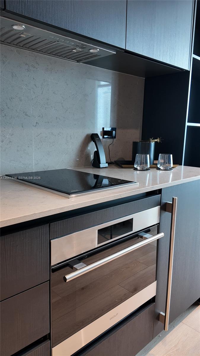 A modern kitchen features dark cabinetry, a light stone countertop, and a Wolf oven — 20 NE 11th St # 1505, Miami FL 33132, MIAMI, FL