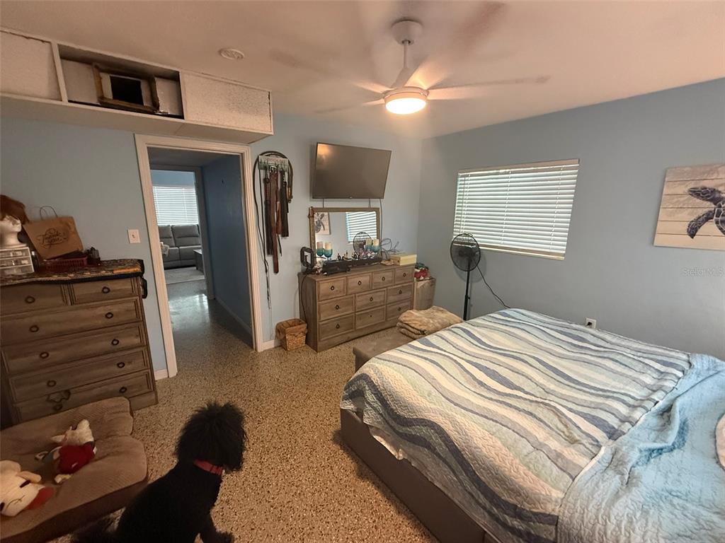 A bedroom features light blue walls, a ceiling fan, a dresser, and a bed — 316 76TH AVENUE, ST PETE BEACH, FL