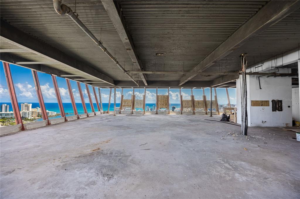 An unfinished high-rise interior features exposed concrete ceilings, support beams, and floor-to-ceiling ocean views — 602 MANUEL FERNÁNDEZ JUNCOS AVENUE UNIT 27, SAN JUAN, PR