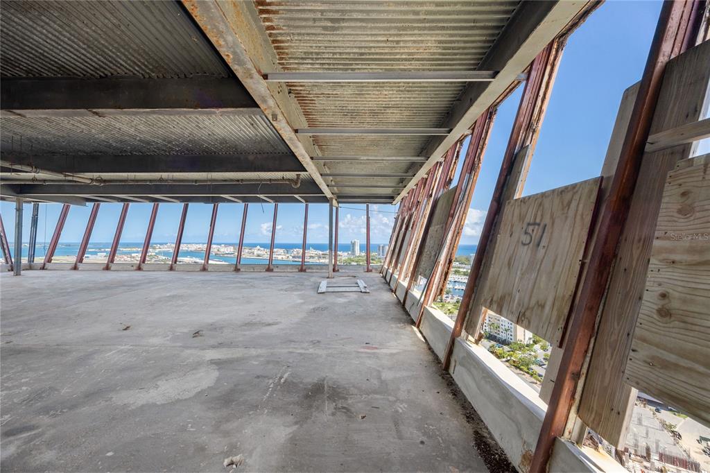 An unfinished high-rise interior features exposed metal ceiling beams, concrete flooring, and plywood-covered window frames — 602 MANUEL FERNÁNDEZ JUNCOS AVENUE UNIT 27, SAN JUAN, PR