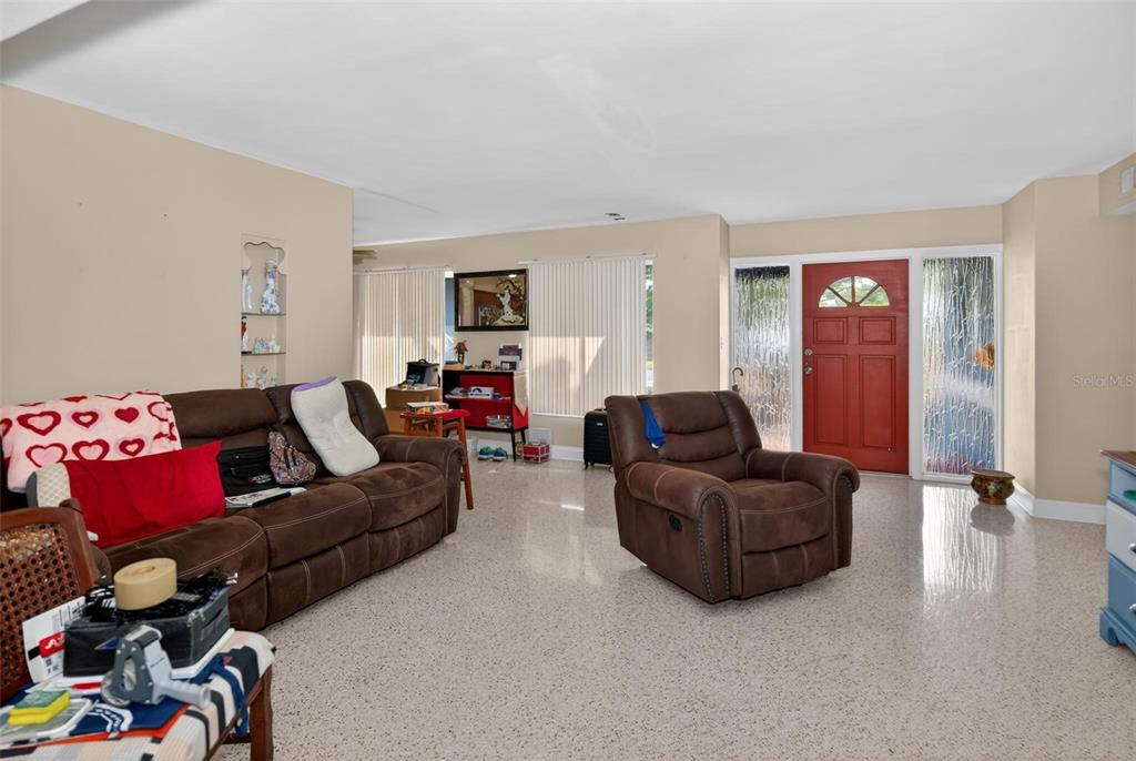 A living room features a brown sofa, a recliner, and light-colored speckled flooring — 3232 59TH WAY N, ST PETERSBURG, FL