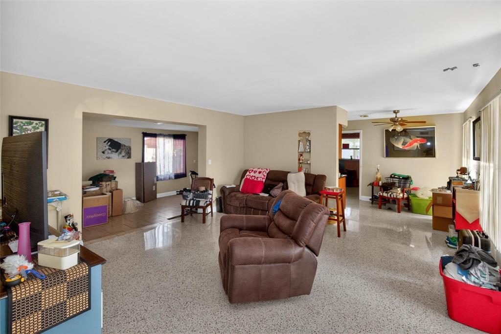 A living room features light-colored terrazzo flooring, beige walls, and brown upholstered furniture — 3232 59TH WAY N, ST PETERSBURG, FL