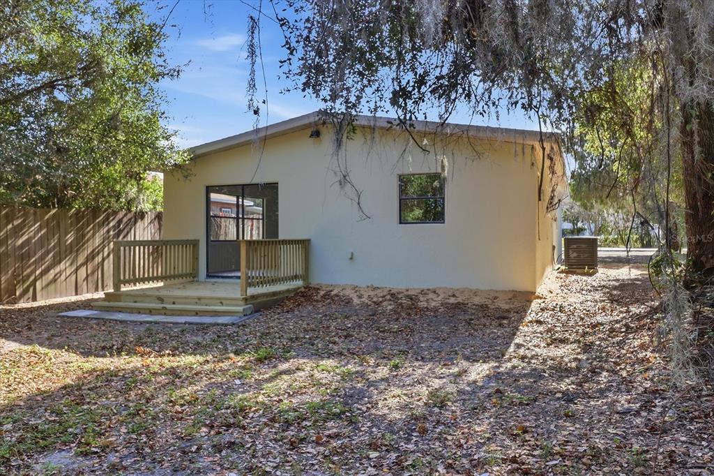 The exterior of a house features a wooden deck, a sliding glass door, and a window — 20473 W MCKINNEY AVENUE, DUNNELLON, FL