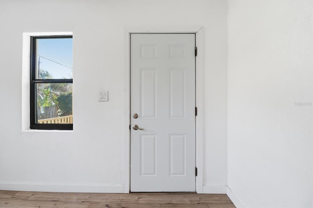 A white door and a window are set into a plain white wall above flooring — 20473 W MCKINNEY AVENUE, DUNNELLON, FL
