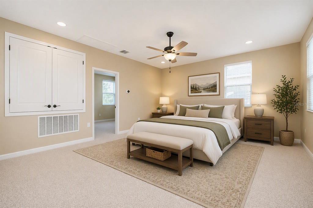 A bedroom features a king bed, a bench, two nightstands, and a ceiling fan — 15403 MURCOTT HARVEST LOOP, WINTER GARDEN, FL