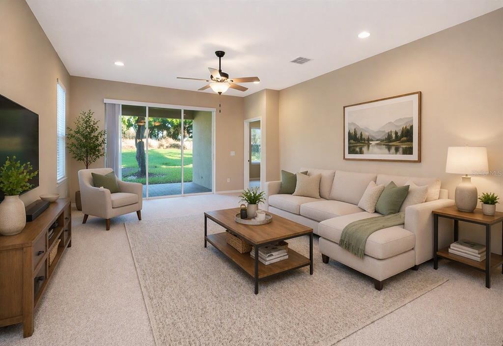 A living room features a beige sectional sofa, a wooden coffee table, and sliding glass doors — 15403 MURCOTT HARVEST LOOP, WINTER GARDEN, FL