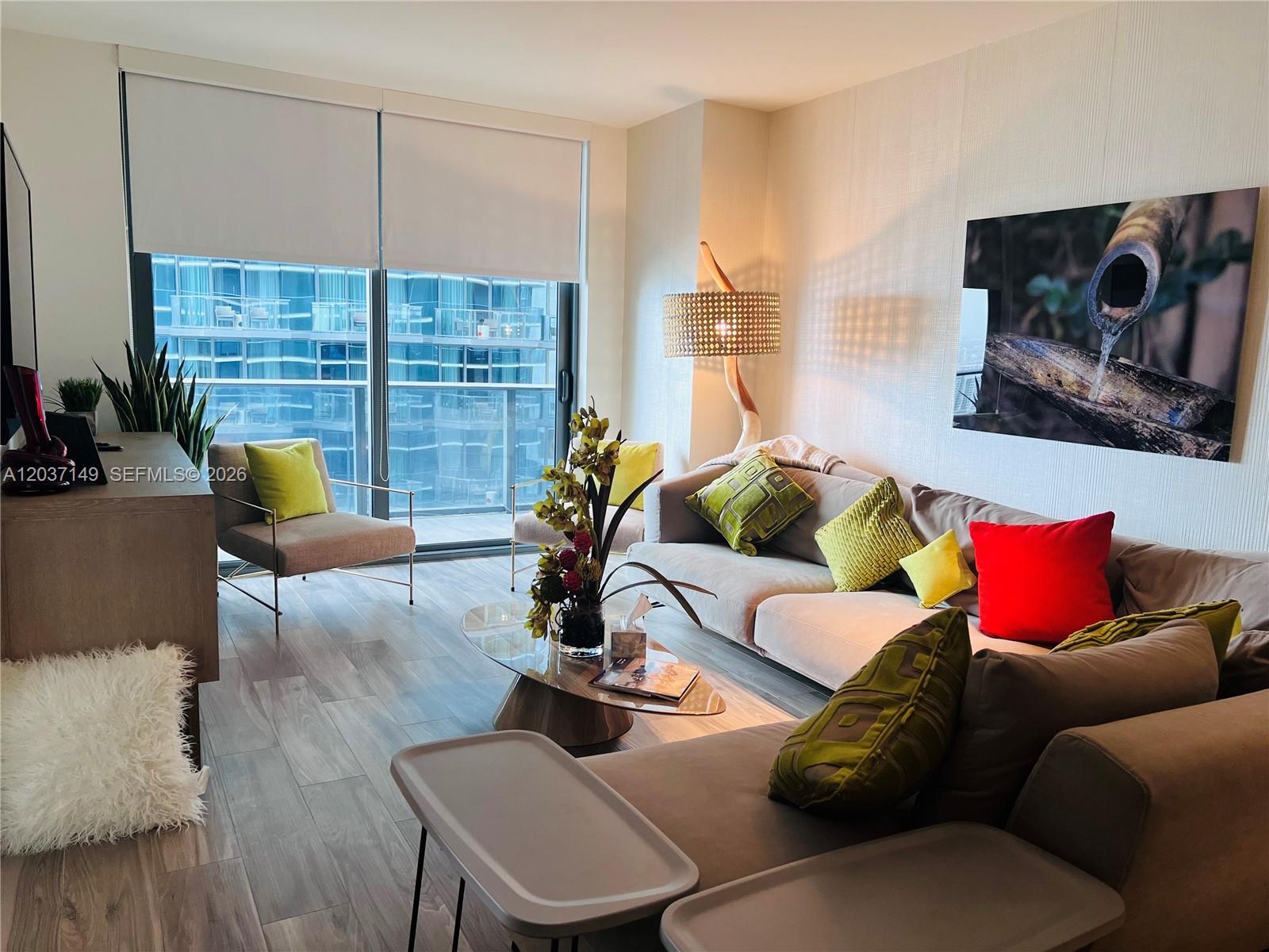 A modern living room features a sectional sofa, accent chairs, and floor-to-ceiling windows — 801 S Miami Ave # 3608, Miami FL 33130, MIAMI, FL