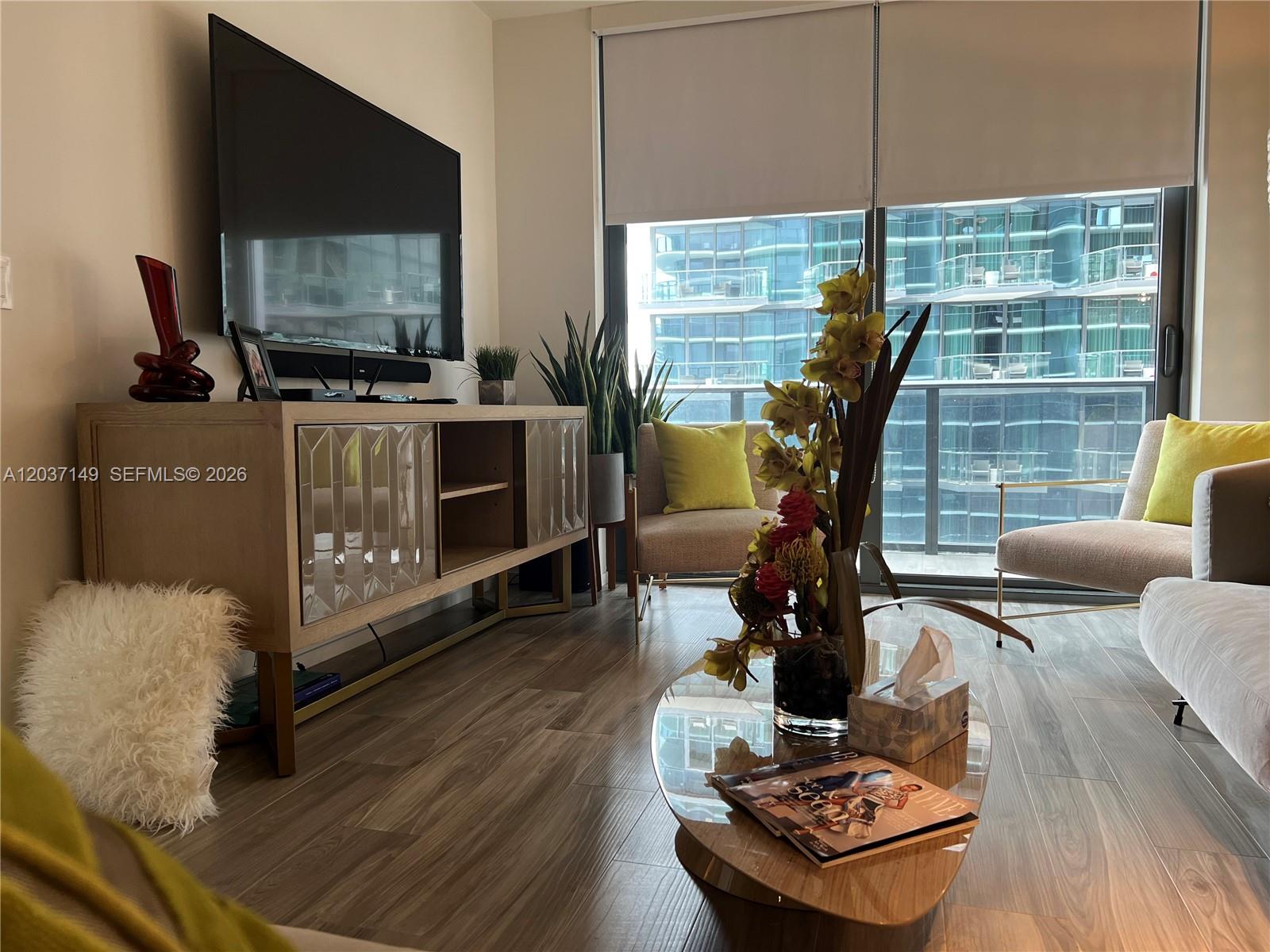 A living room features a television console, two armchairs, and a glass coffee table — 801 S Miami Ave # 3608, Miami FL 33130, MIAMI, FL