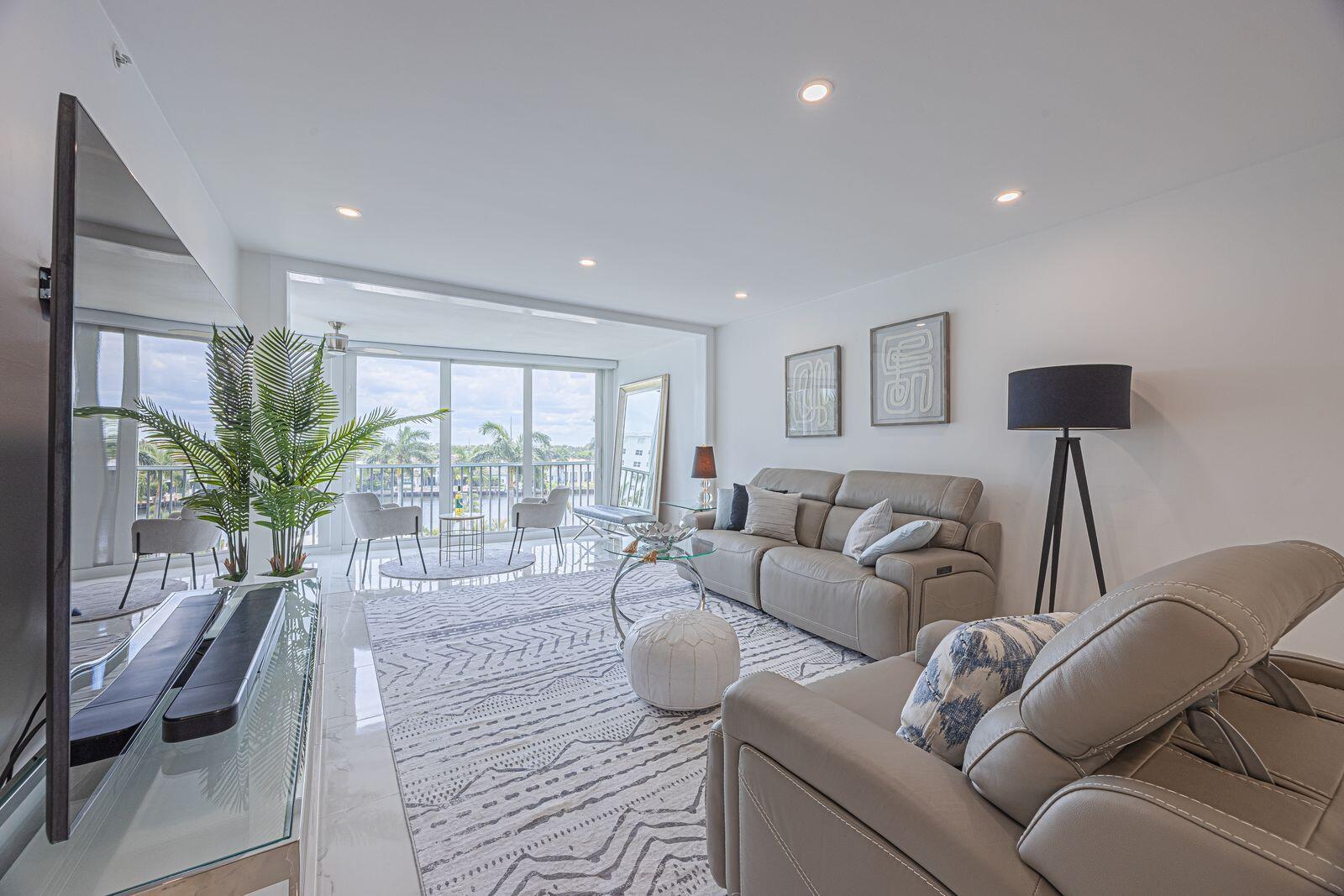 A modern living room features light leather furniture, a patterned rug, and a glass balcony door — 3224 S Ocean Boulevard # 612b, Highland Beach FL 33487, HIGHLAND BEACH, FL