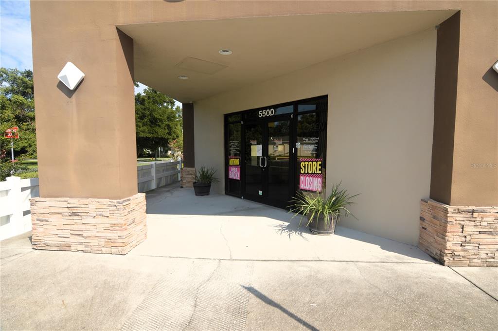 The exterior entrance of a commercial building features a glass door and stone-accented pillars — 5500 6TH STREET, ZEPHYRHILLS, FL