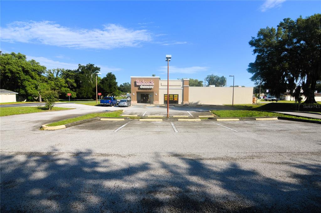 A commercial building with a parking lot under a clear blue sky — 5500 6TH STREET, ZEPHYRHILLS, FL