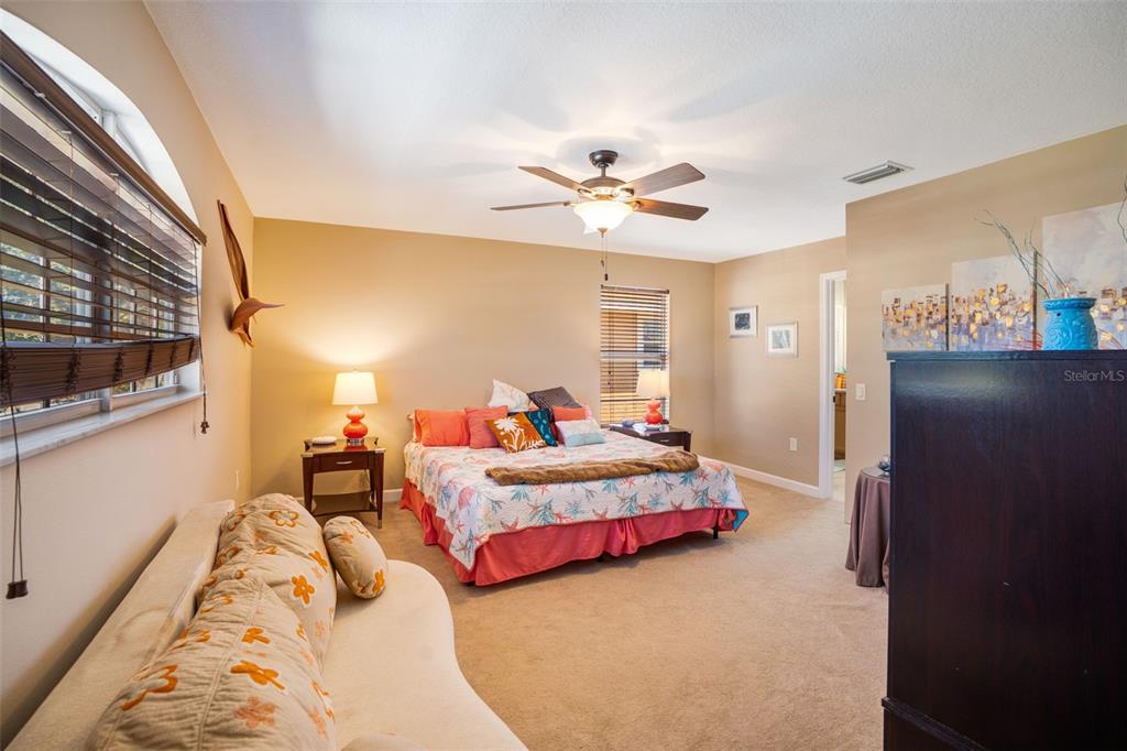 A bedroom with a bed, a sofa, a ceiling fan, and windows with blinds — 2890 ASHTON ROAD UNIT 5, SARASOTA, FL