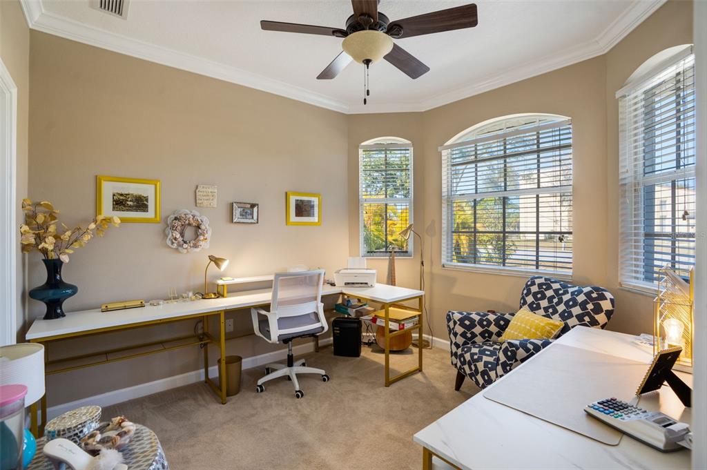 A home office features two desks, a patterned armchair, and large windows with blinds — 2890 ASHTON ROAD UNIT 5, SARASOTA, FL