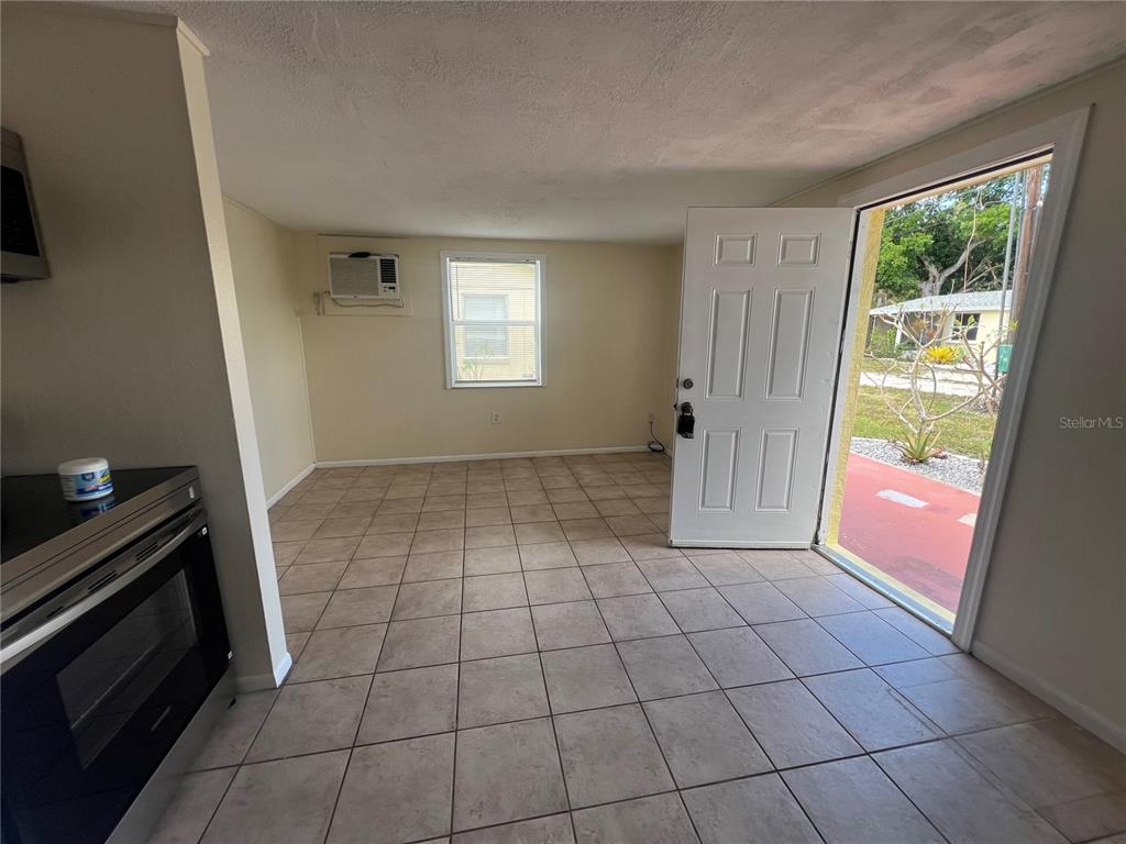 A kitchen with tiled floors and an open door leading to an outdoor area — 255 PINEAPPLE STREET UNIT 3, ENGLEWOOD, FL