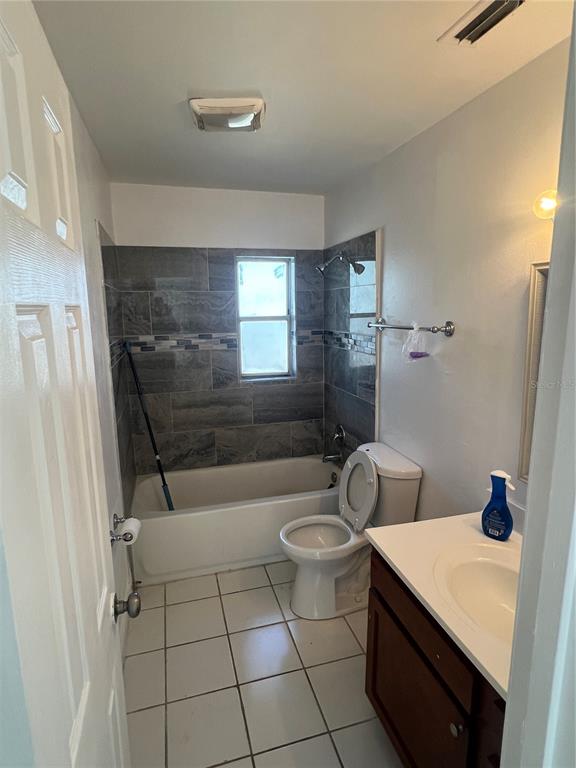 A bathroom features a tiled tub-shower combination, a white toilet, and a dark wood vanity — 1908 HONOUR RD UNIT 3, ORLANDO, FL