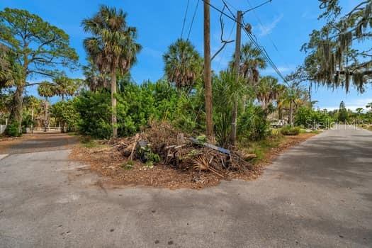 A dirt and debris pile sits at the intersection of two paved residential streets — 7822 WILMAR COURT, PORT RICHEY, FL