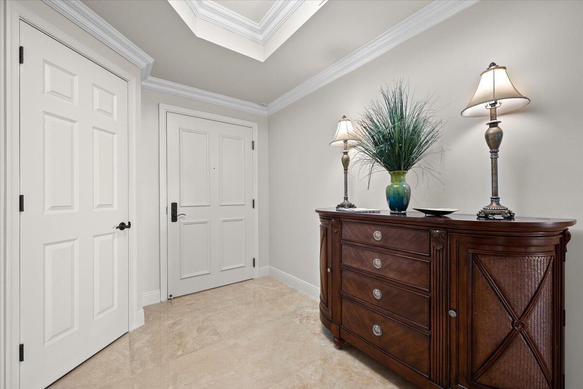 A foyer features a dark wood dresser, two lamps, a plant, and two white doors — 500 S Us Hwy 1 # 402, Jupiter FL 33477, JUPITER, FL