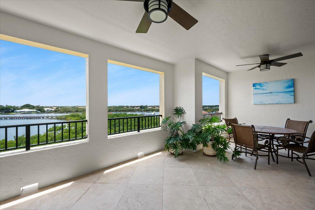 A covered balcony with tile flooring, ceiling fans, outdoor furniture, and views of the water — 500 S Us Hwy 1 # 402, Jupiter FL 33477, JUPITER, FL