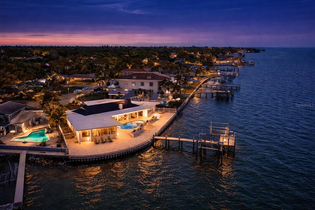 An aerial view of a waterfront house at dusk featuring a pool and private dock — 2970 68TH AVENUE S, ST PETERSBURG, FL