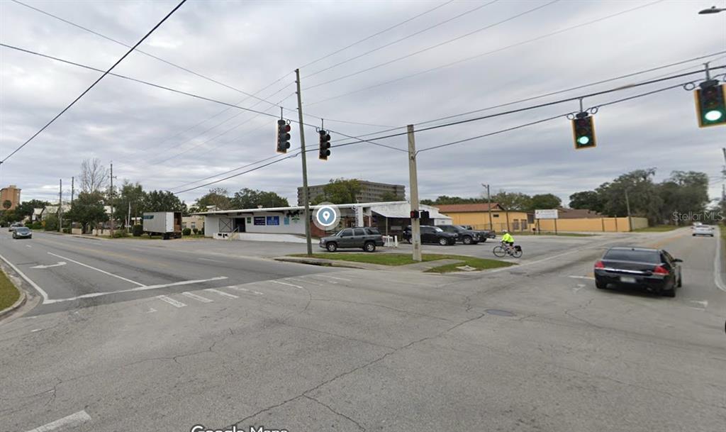 A street-level view of a commercial building at an intersection with traffic lights — 247 S AMELIA AVENUE, DELAND, FL