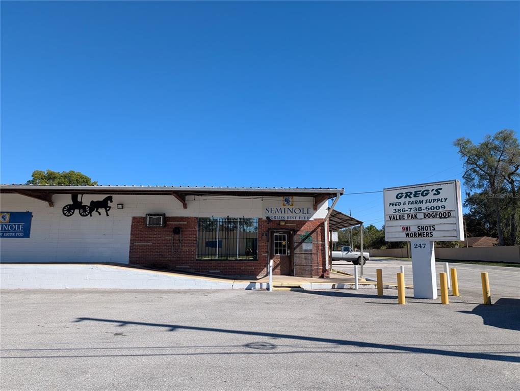 A single-story commercial building with a brick facade and a prominent roadside sign — 247 S AMELIA AVENUE, DELAND, FL