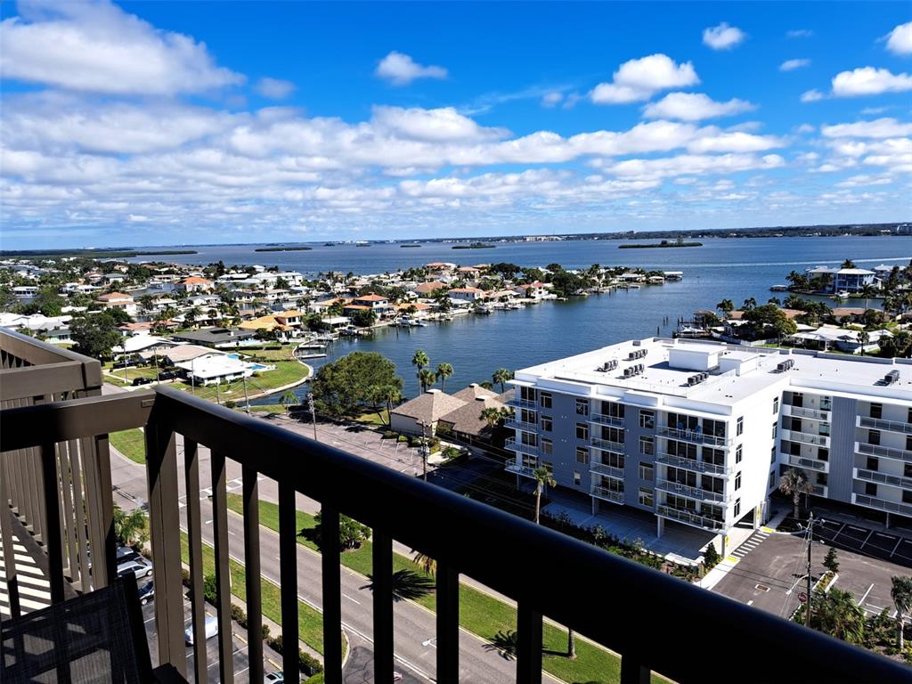 A high-angle view from a balcony overlooking a coastal neighborhood, a waterway, and a building — 400 ISLAND WAY UNIT 1409, CLEARWATER BEACH, FL