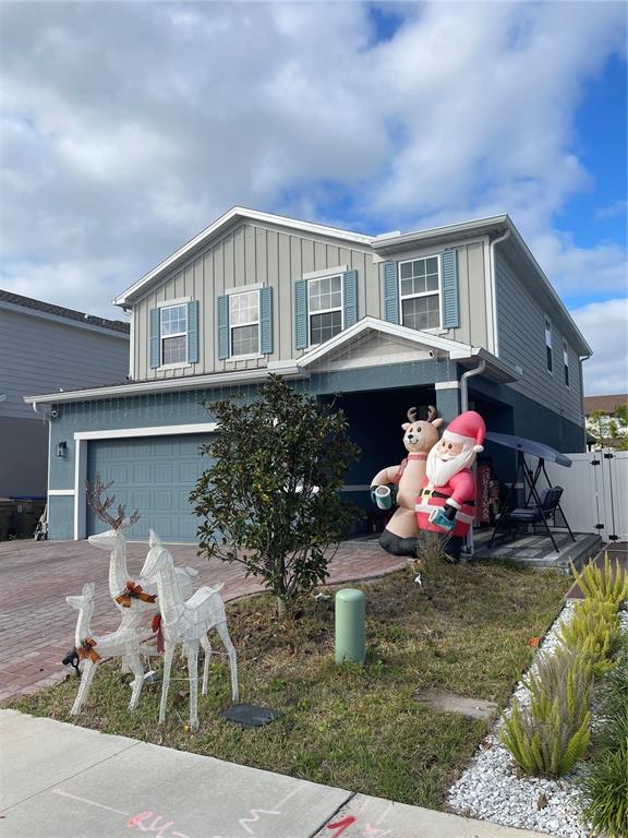A two-story house features a gray exterior with Christmas decorations in the front yard — 3182 ARMSTRONG SPRING DRIVE, KISSIMMEE, FL