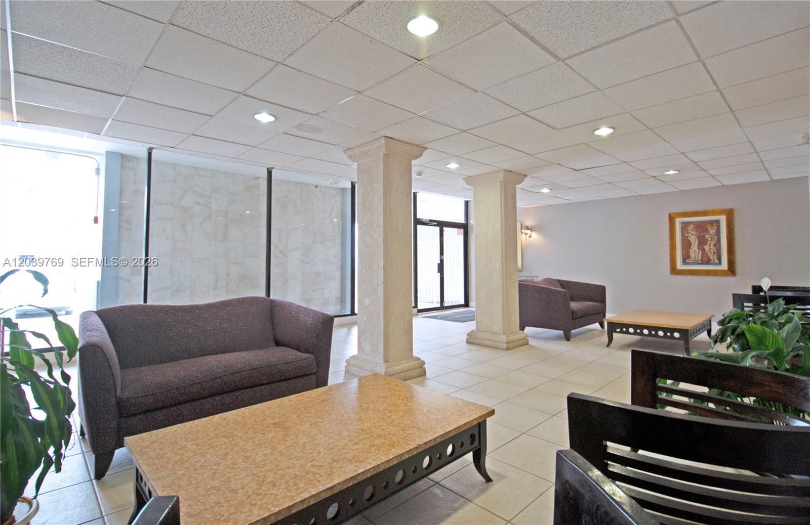 A lobby area features tiled floors, two stone columns, purple sofas, and coffee tables — 2016 Bay Dr # 201, Miami Beach FL 33141, MIAMI BEACH, FL