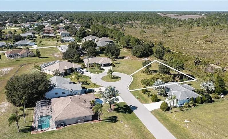 An aerial view shows a residential neighborhood with a highlighted vacant lot — 30 MOCHA COURT, PUNTA GORDA, FL
