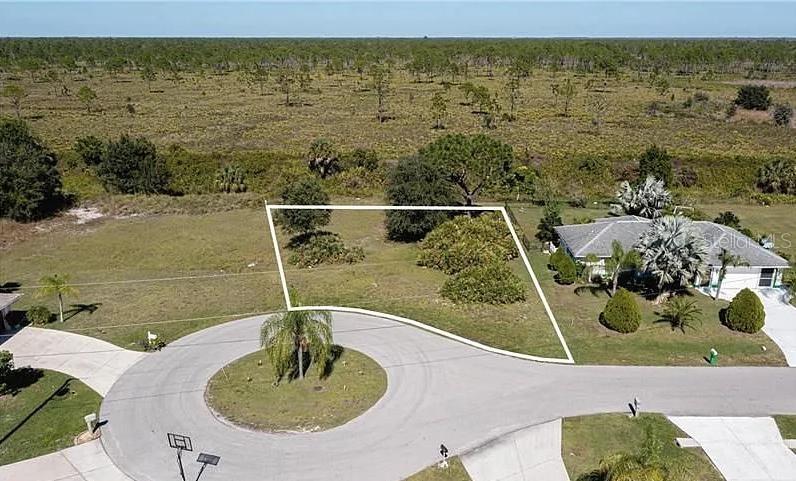 An aerial view shows a vacant residential lot outlined in white within a cul-de-sac — 30 MOCHA COURT, PUNTA GORDA, FL